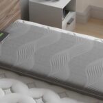 Luxurious gray mattress with wave pattern in modern bedroom on wooden bed frame.