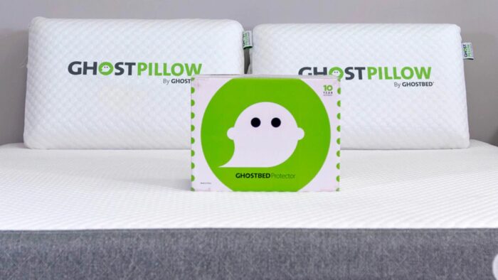 Modern bedroom with GHOSTPILLOWs by GHOSTBED on grey mattress, emphasizing comfort and style.