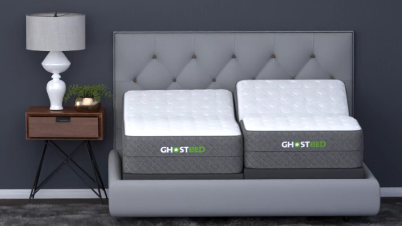 Modern bedroom featuring GhostBed mattresses with a grey tufted headboard and elegant nightstand.