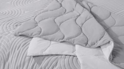 Modern gray quilt with elegant wave patterns and white contrast, enhancing bedroom tranquility.