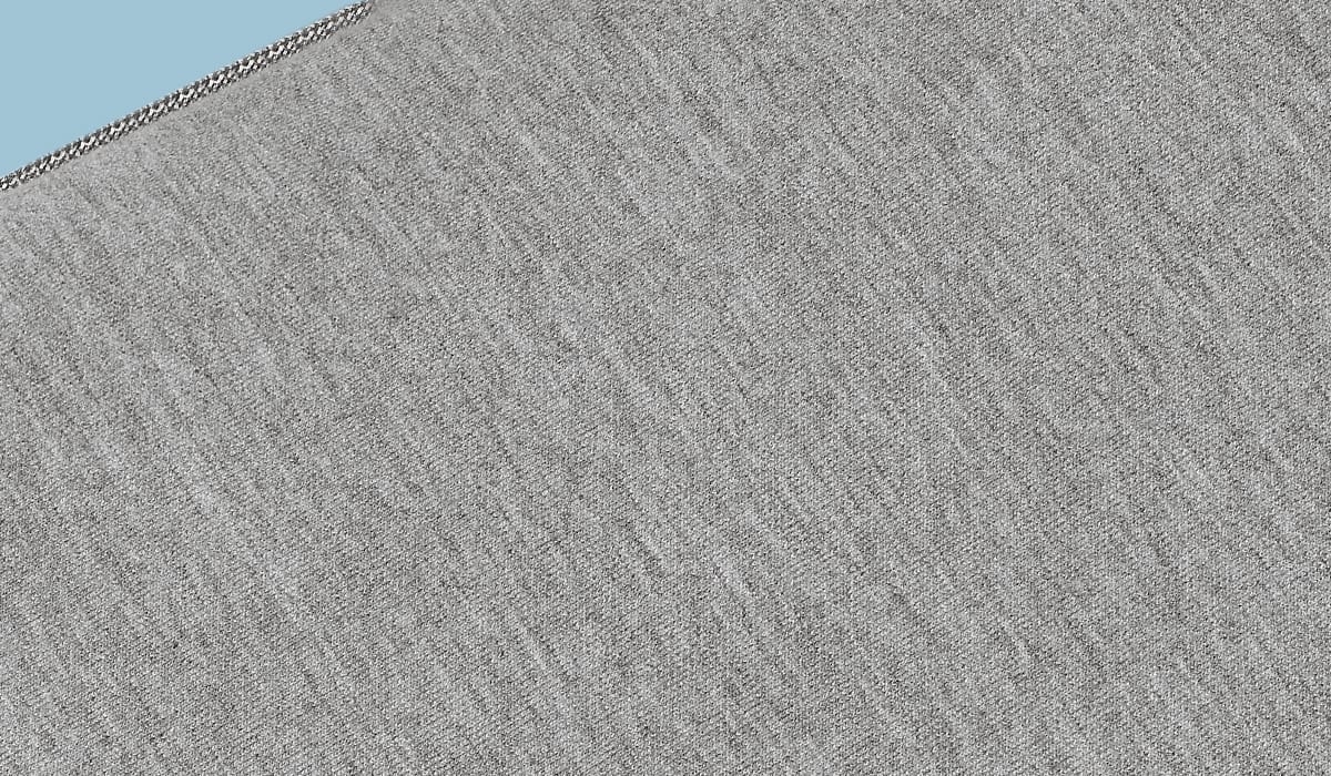 Textured gray fabric close-up on a blue background, showcasing stitching and cozy appeal.