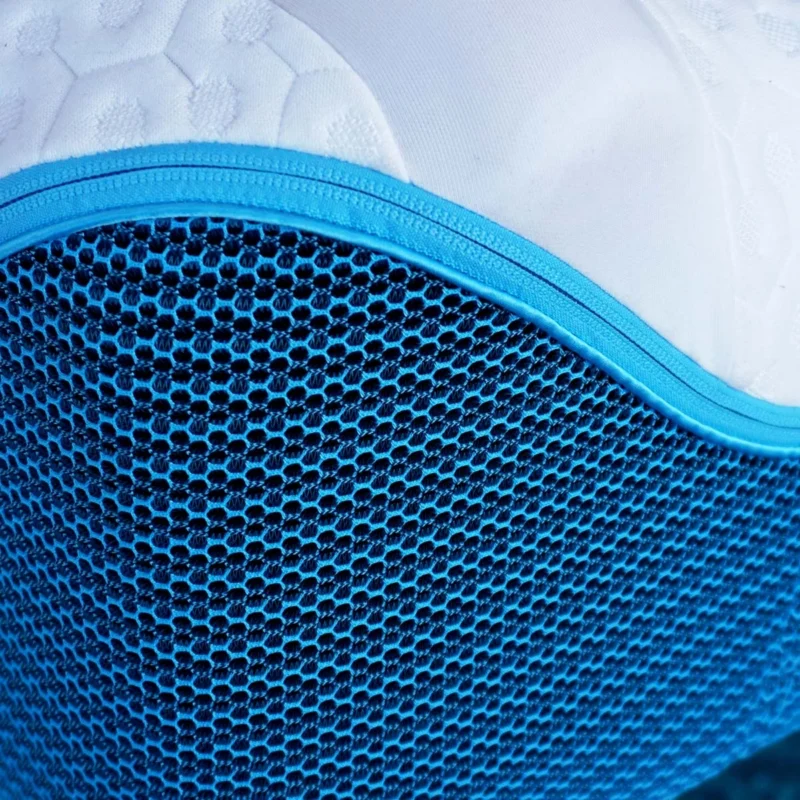 Ergonomic cushion with honeycomb mesh for breathability, white surface, blue trim.
