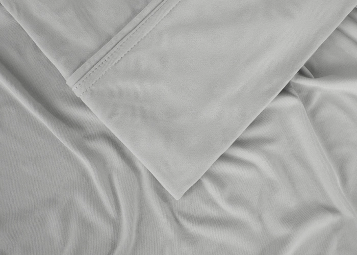 Close-up of gray fabric with sheen and seam, ideal for bedding and home decor.