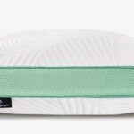 Modern pillow with curved design, mint green accents, and embossed textured white surface.