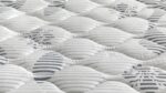 Modern mattress with stylish wavy patterns, white and gray tones, offering comfort and quality.