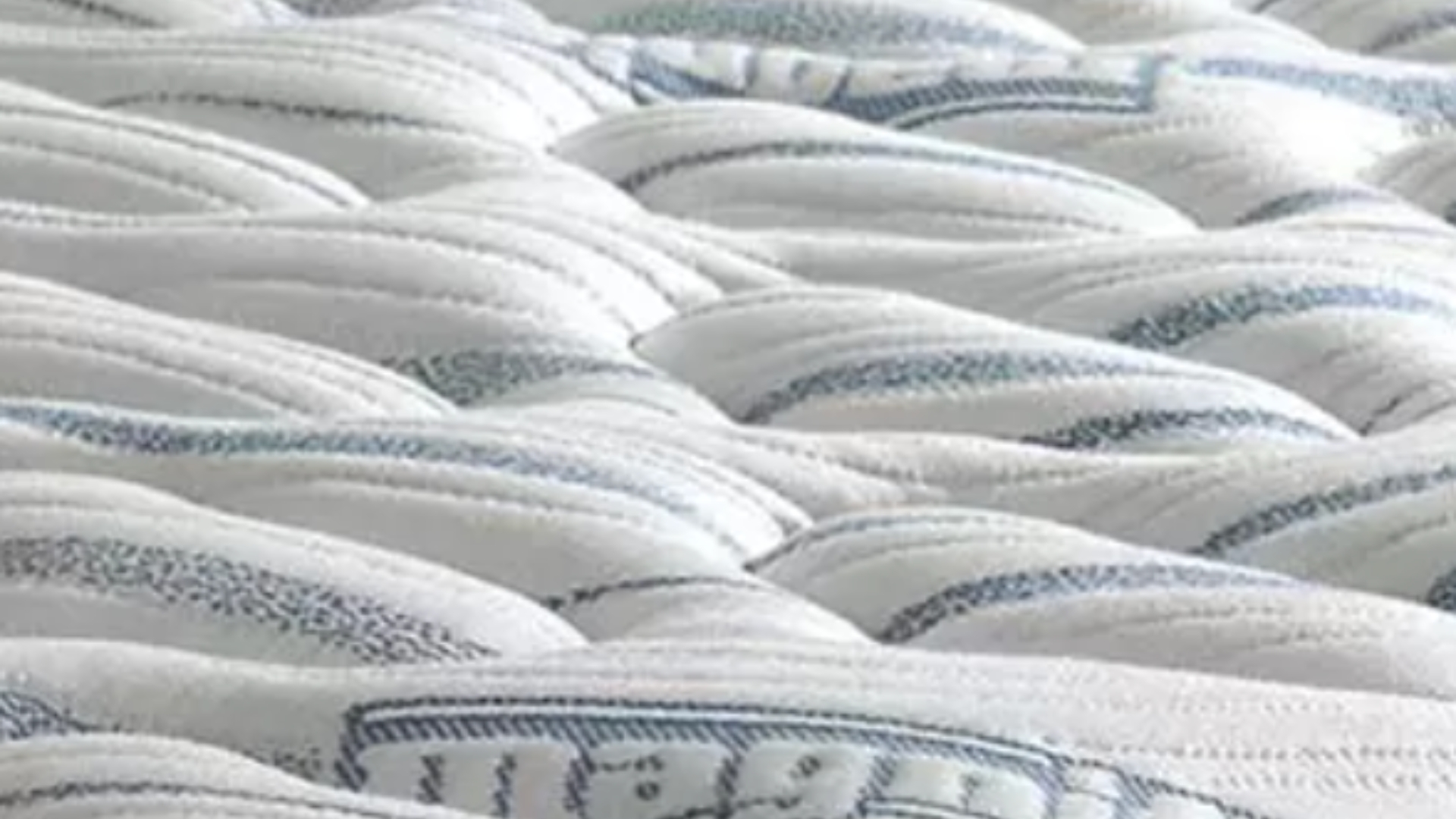 Close-up of a luxurious white quilted mattress highlighting comfort, support, and elegant design.