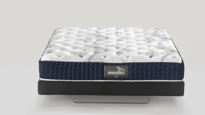 White tufted mattress with navy border against neutral background for stylish, modern comfort.