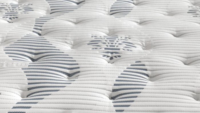 Close-up of white tufted mattress with modern floral and striped patterns.