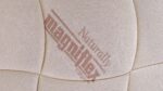 Close-up of Magniflex Firm Mattress, cream texture, modern design, quality craftsmanship for comfort.