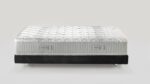 Luxury quilted mattress with side handles and black base for modern bedroom support.