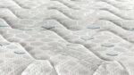 Close-up of quilted mattress with wave texture and hexagonal patterns for comfort and airflow.