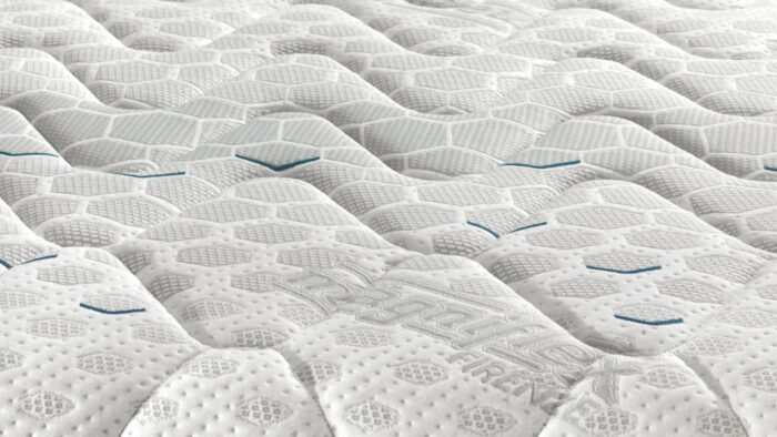 Close-up of quilted mattress with wave texture and hexagonal patterns for comfort and airflow.