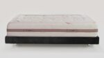 Plush cream quilted mattress on black minimalist bed frame, tranquil and luxurious design.