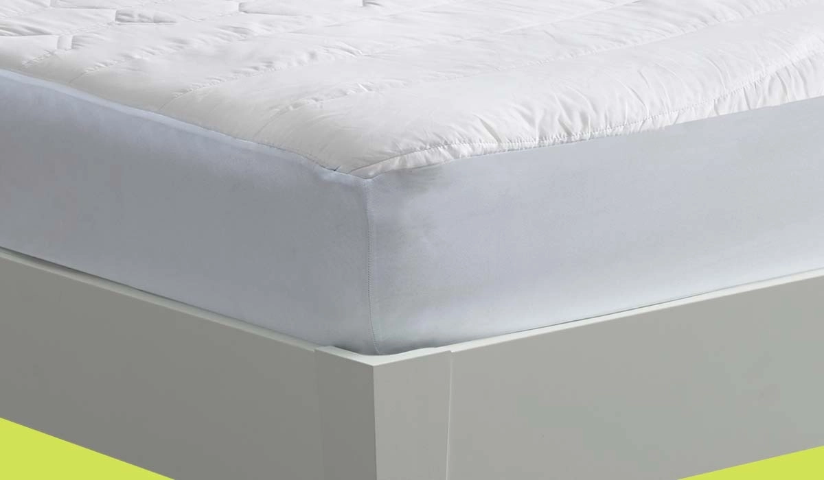 Close-up of quilted white mattress corner on sleek gray bed frame for modern bedroom comfort.