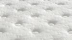 Close-up of a white plush tufted mattress for ultimate comfort and luxurious sleep.