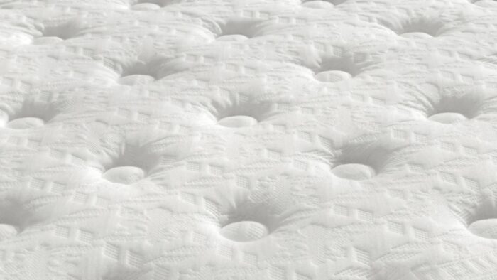 Close-up of a white plush tufted mattress for ultimate comfort and luxurious sleep.