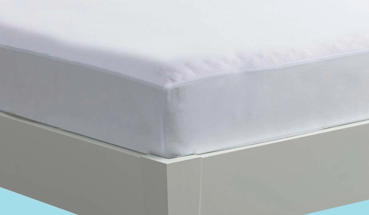 Close-up of white mattress cover fitting snugly on a minimalist platform bed.