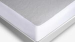 Gray quilted mattress with a modern white border, highlighting comfort and contemporary design.