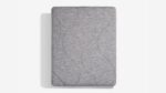 Gray mattress with wavy stitching on a white background suggesting comfort and elegance.