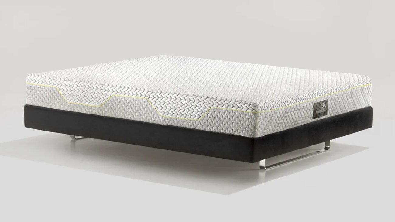 Modern mattress with geometric pattern and black base, elevated on metal legs.