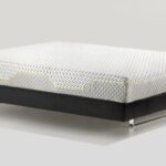 Modern mattress with geometric pattern and black base, elevated on metal legs.
