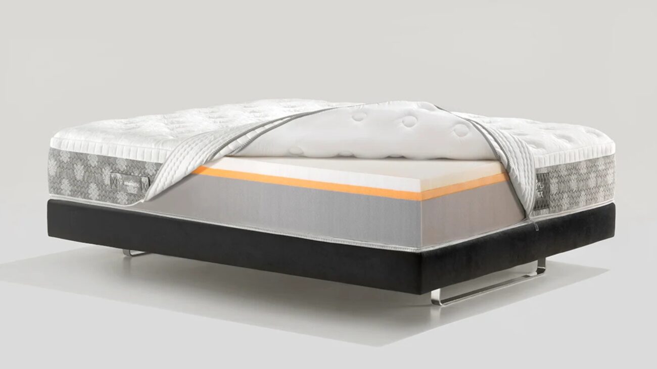 Modern mattress with layered design on sleek black bed frame.