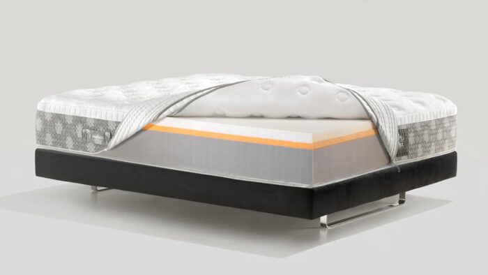 Modern mattress with layered design on sleek black bed frame.