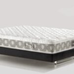 Tufted modern mattress on sleek black base with geometric sides for style and comfort.