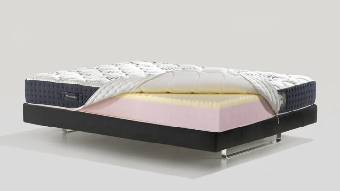 Modern ergonomic mattress on sleek black frame, featuring quilted top and foam layers.