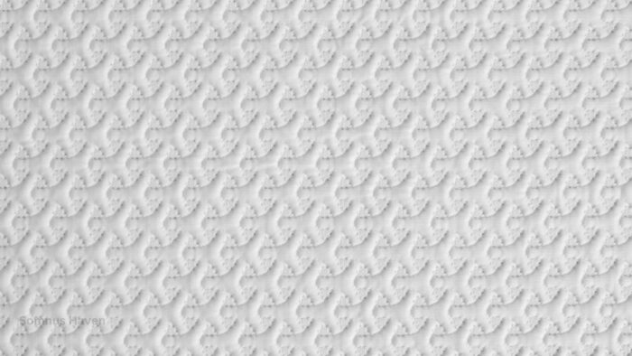 Intricate white textured surface with abstract knot patterns for decor or textiles.