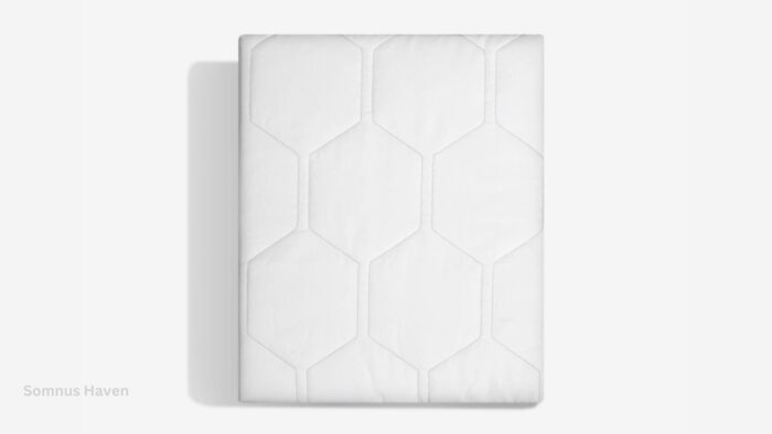 White hexagonal quilted mattress on light background, highlighting modern texture and elegance.