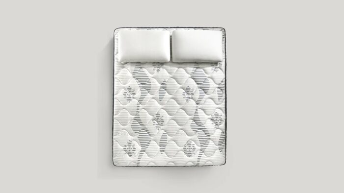 Elegant quilted mattress with plush pillows, showcasing craftsmanship and luxurious comfort.