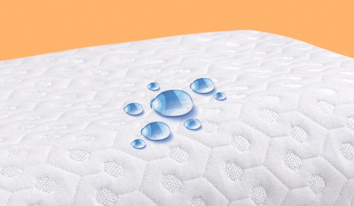 Waterproof mattress with breathable honeycomb design and water droplets on a clean white surface.