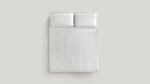 Minimalist bedspread with plush pillows for a tranquil, modern bedroom decor.