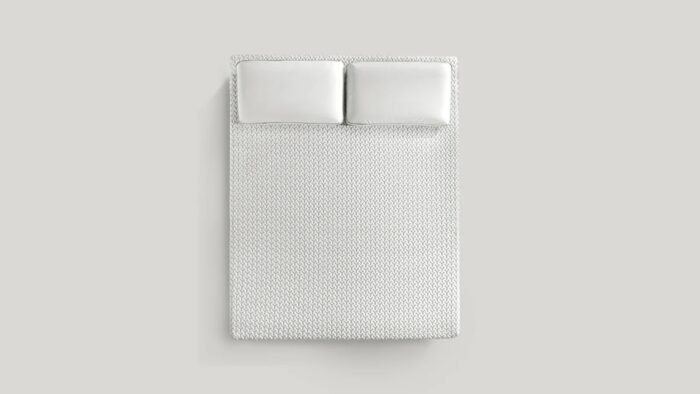 Minimalist bedspread with plush pillows for a tranquil, modern bedroom decor.