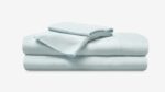 Pastel blue bed linen set: fitted sheet, flat sheet, and pillowcase, offering comfort and tranquility.