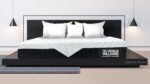 Contemporary dark wood bed with elegant bedding, pendant lighting, and minimalist decor.