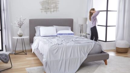 Modern bedroom with grey tones, natural light, and minimalist decor.