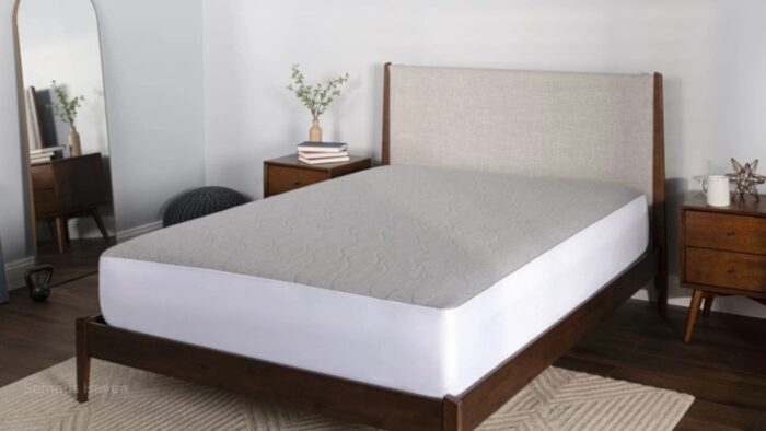 Modern wooden bed with upholstered headboard, mirrored wall, and minimalist decor.