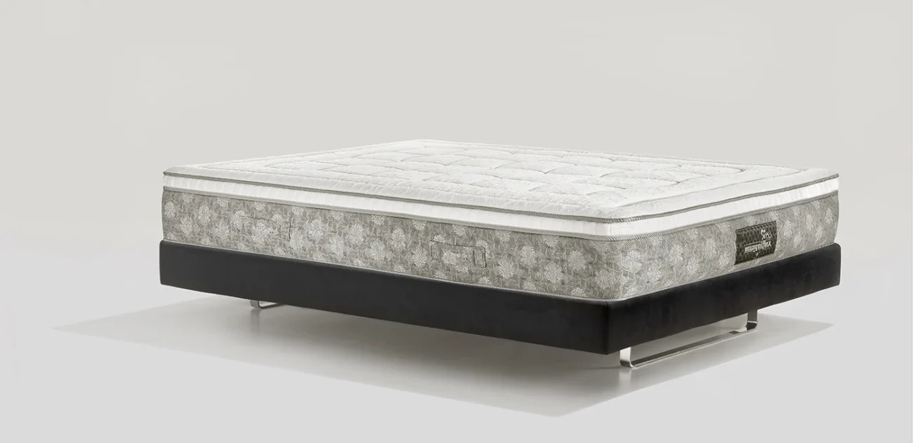 Luxury dual-tone mattress with intricate quilted patterns on a sleek black base and metallic legs.
