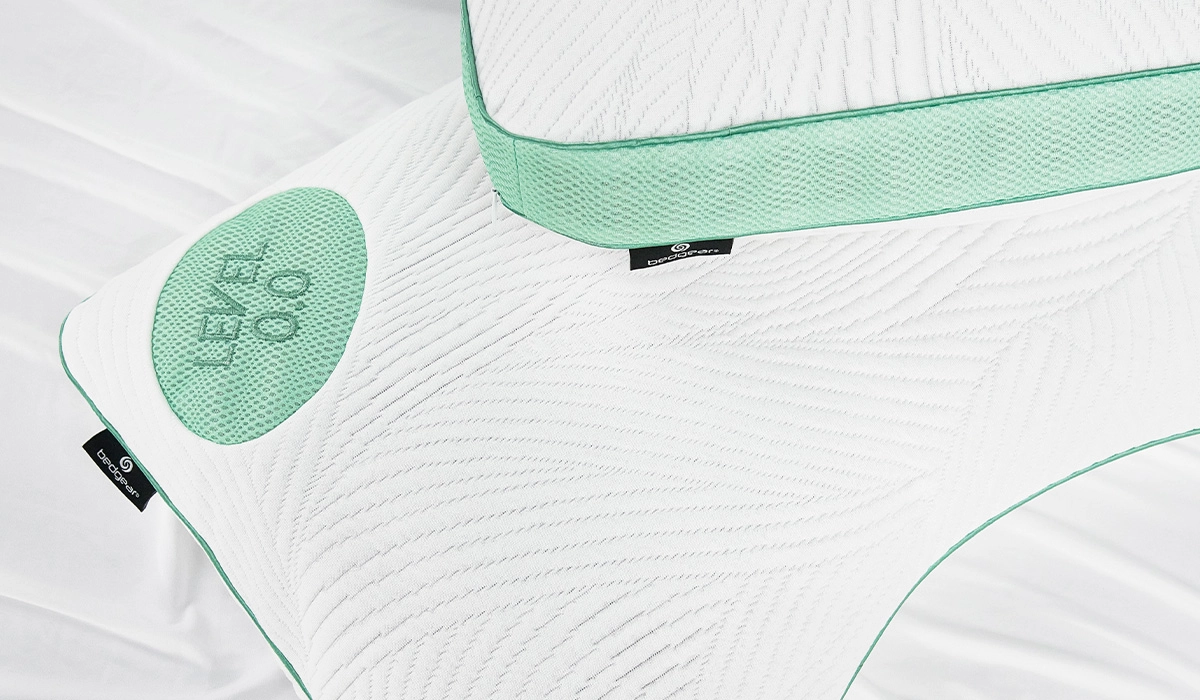 Modern white pillow with wave pattern, pastel green accents, and customizable firmness.