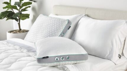 Minimalist bedroom with ergonomic pillows, sleek headboard, and potted plant for tranquil sleep.