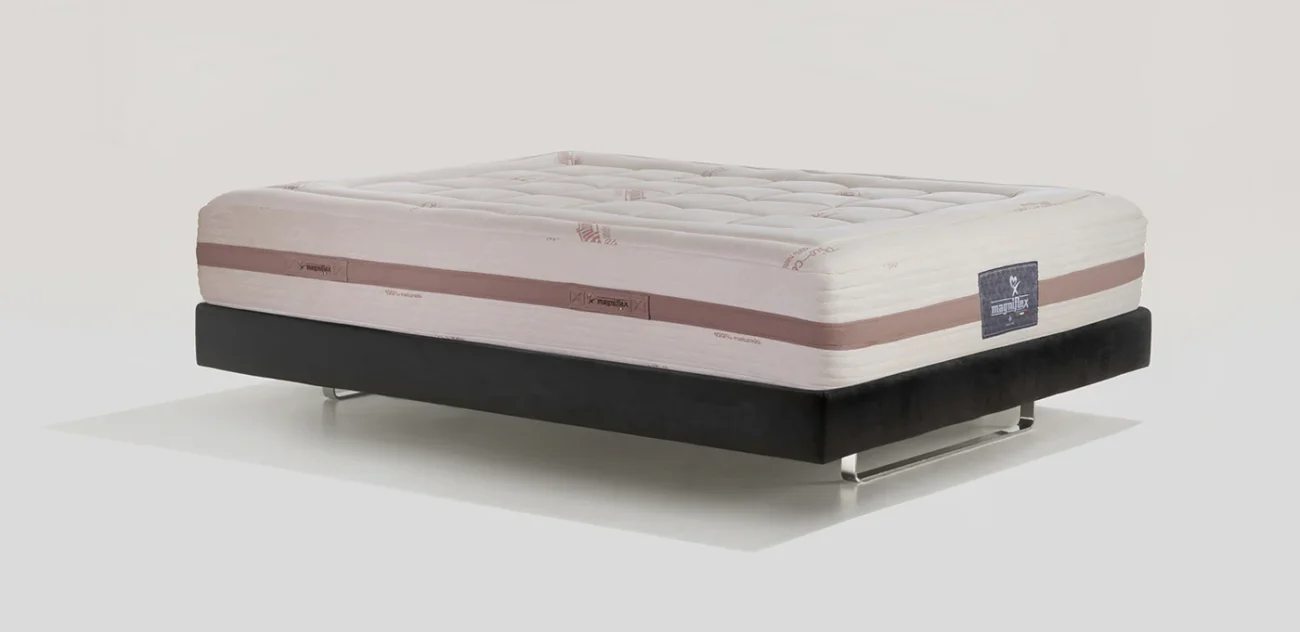 Luxurious off-white mattress on sleek black platform base with tufted top and rose stripe.