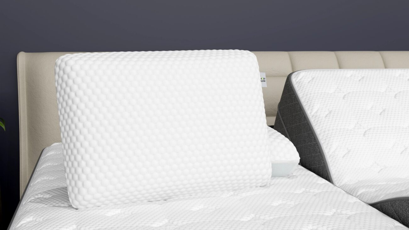 Textured memory foam pillows on modern beige bed with calm dark gray backdrop.