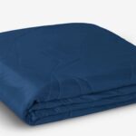 Navy blue satin quilt: elegant, minimalistic, and cozy for stylish room aesthetics.