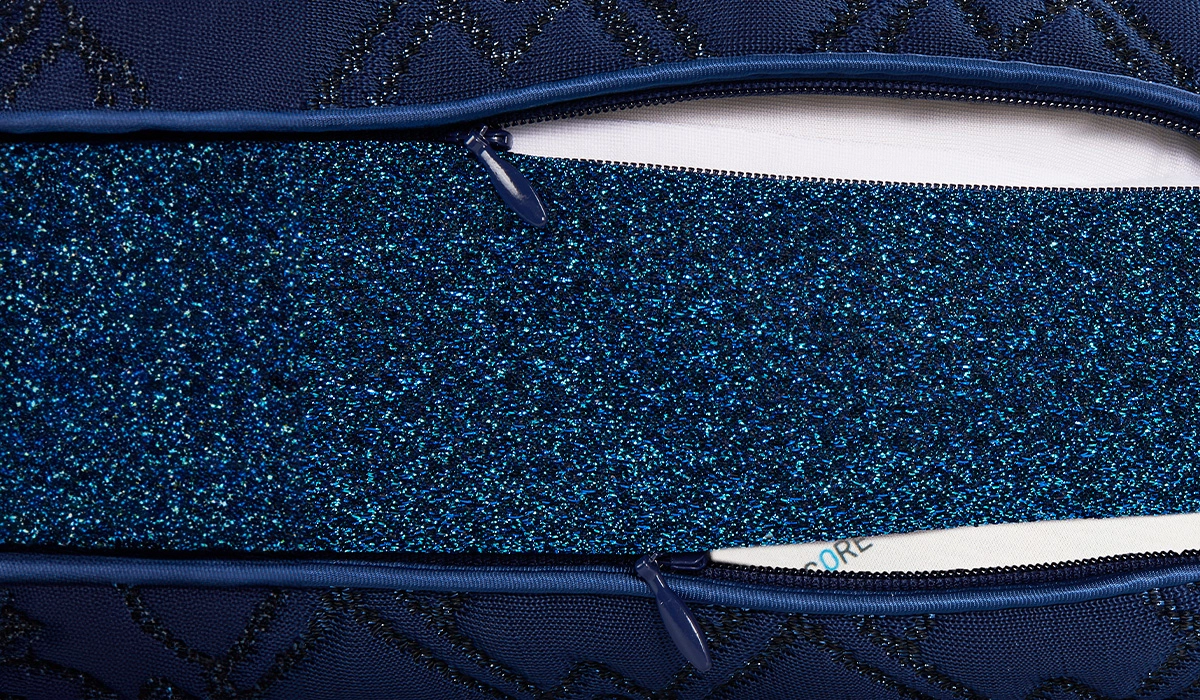 Navy quilted case with glittery teal interior and elegant, durable zipper design.