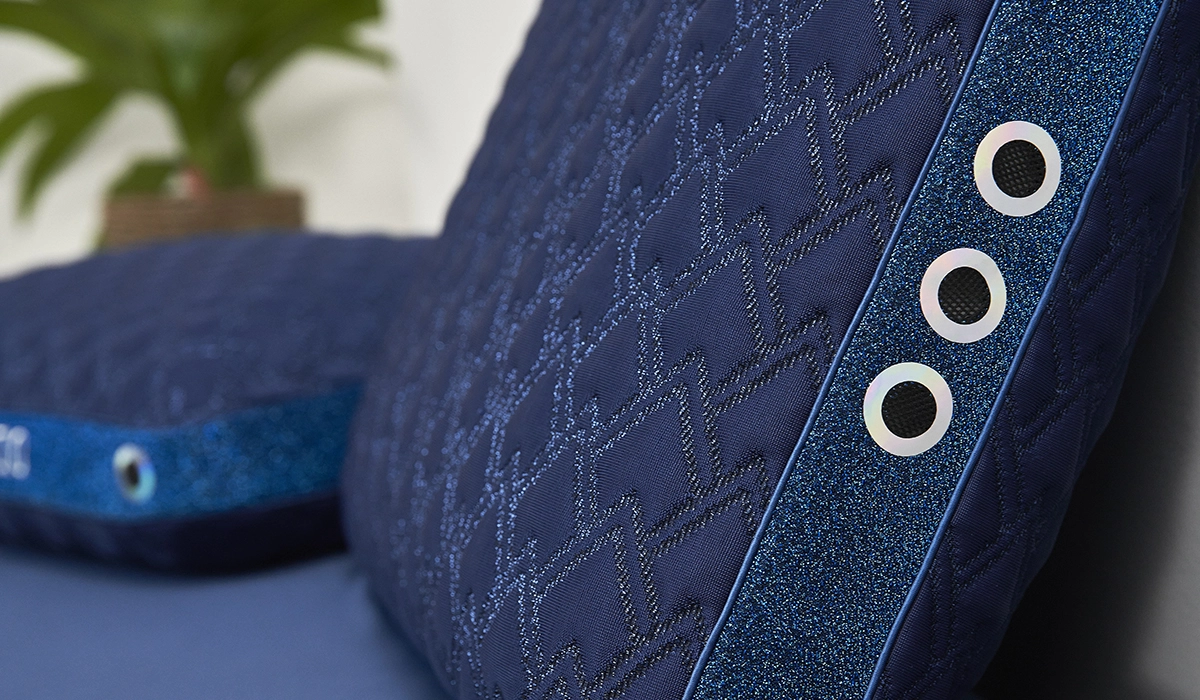 Navy blue pillows with modern accents and foliage backdrop for a sophisticated setting.