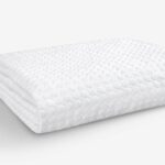 Textured white ergonomic pillow for comfort and support in a minimalist setting.
