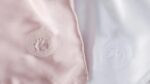 Silky pink and white satin fabrics, featuring elegant embroidery designs.