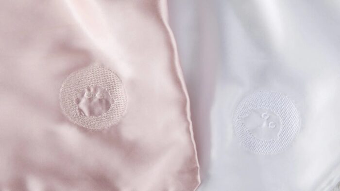 Silky pink and white satin fabrics, featuring elegant embroidery designs.